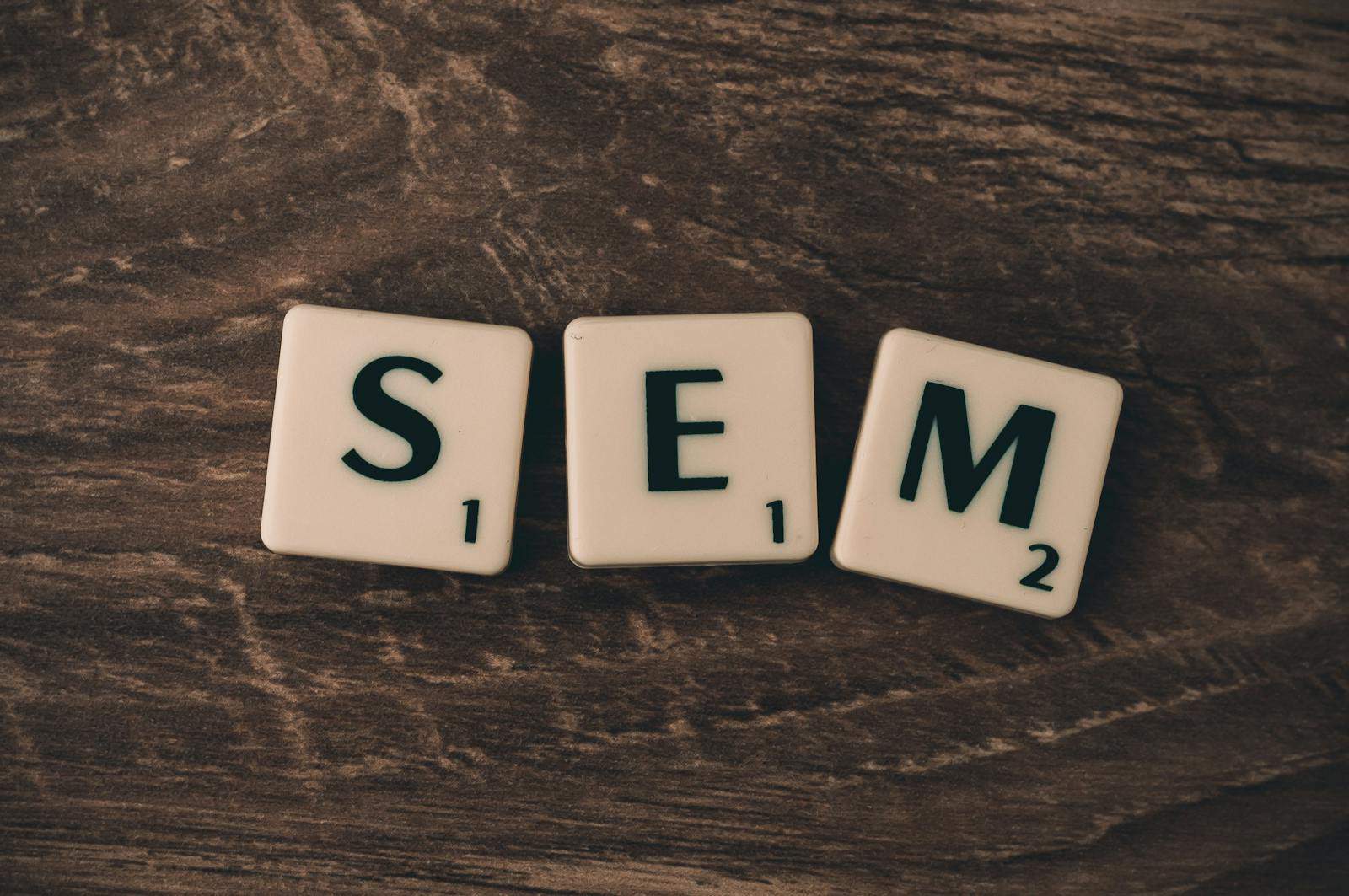 Wooden background with letter tiles spelling SEM, representing search engine marketing. seo, sem, analytics