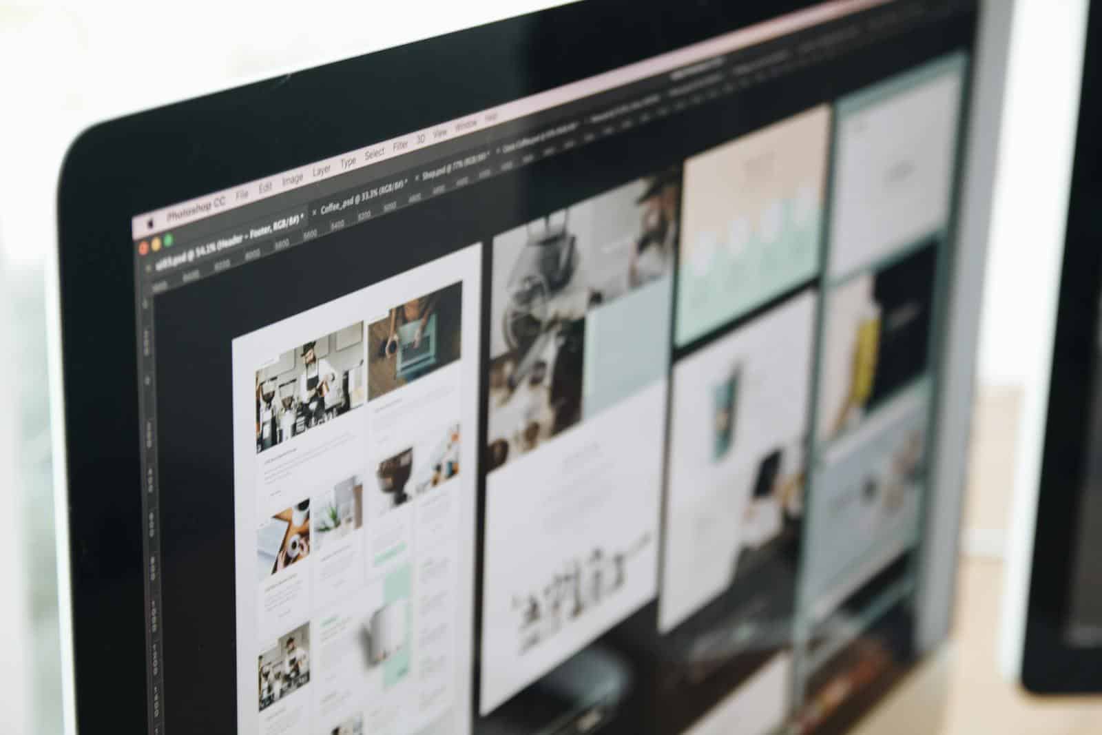 A modern computer screen displaying web design work, showcasing creative visuals in a workspace. Website Maintenance
