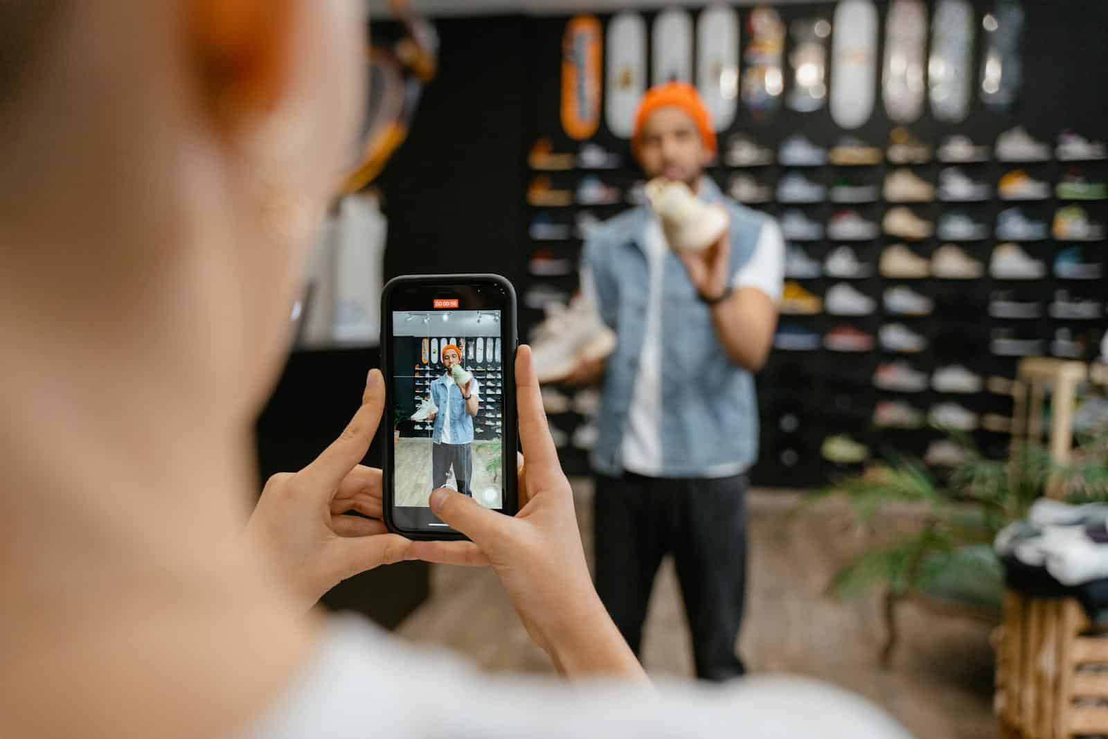 Person filming a shoe shopping experience in a trendy store using a smartphone. Analytics